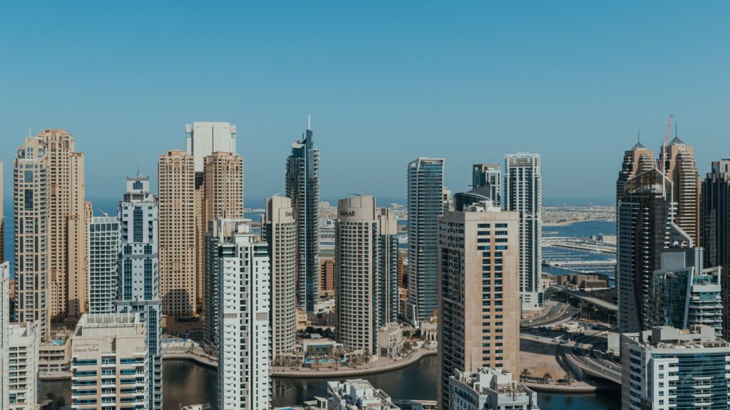 Panoramic aerial view of Dubai's modern skyline with dense high-rise towers under a clear blue sky