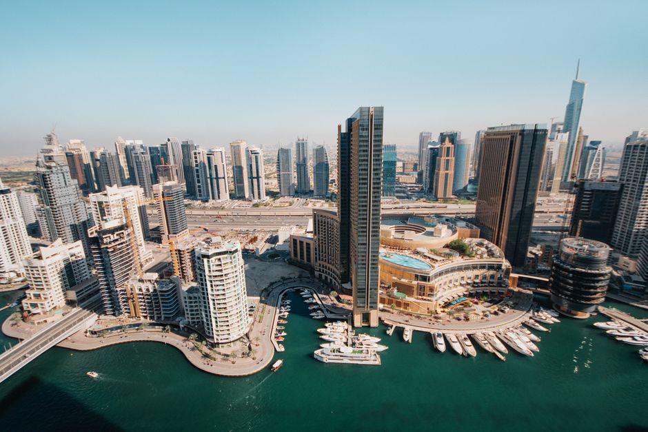 Aerial view of a Dubai waterfront skyline with yachts and high-rise towers, representing The Crest in Sobha Hartland