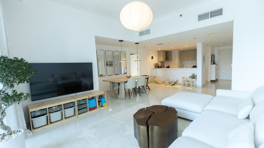 Bright modern Dubai apartment living room with open-plan kitchen and dining area, representative of apartment interiors in Town Square, Dubailand, near Hayat Boulevard 1A