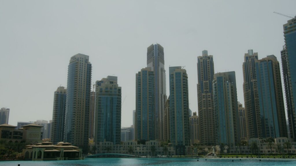 Business Bay skyline of high-rise towers reflecting in the Dubai Water Canal under an overcast sky