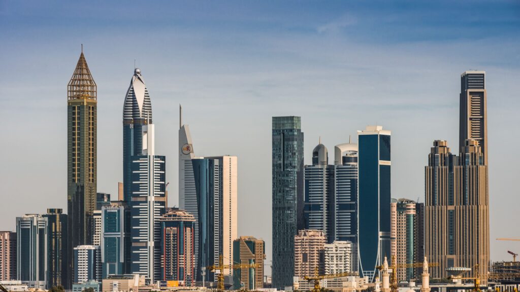Dubai skyline of distinct high-rise towers in daylight under a clear blue sky, no people or legible signage visible