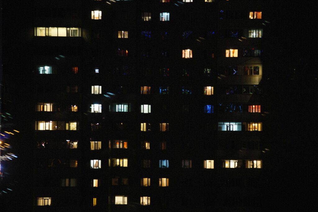 Lit windows on the facade of a residential high-rise at night in Dubai