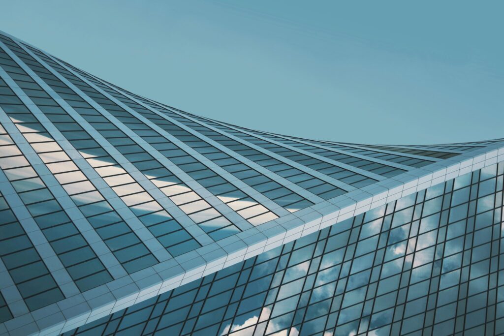 Curved glass tower facade against a clear sky near Paloma Tower, Dubai Marina