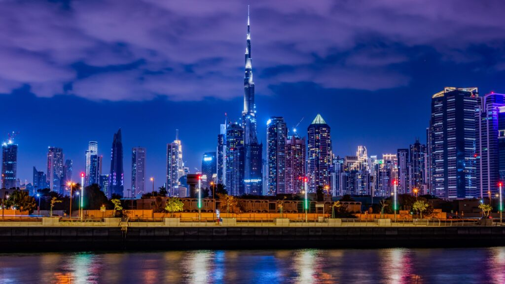 Downtown Dubai skyline with the illuminated Burj Khalifa reflected across the water at night