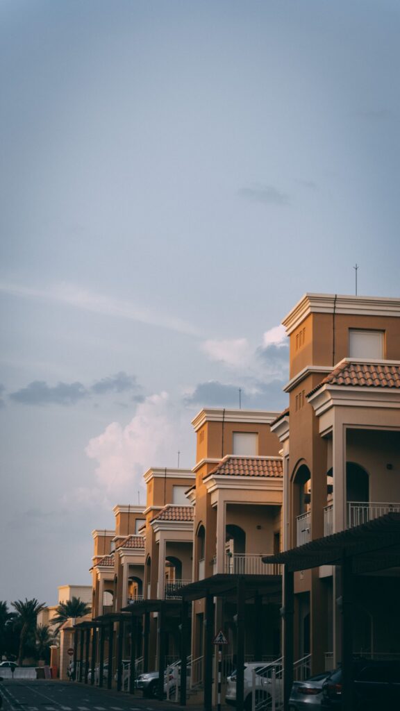 Row of Mediterranean-style townhouses with tiled roofs and arched windows in a Dubai residential community