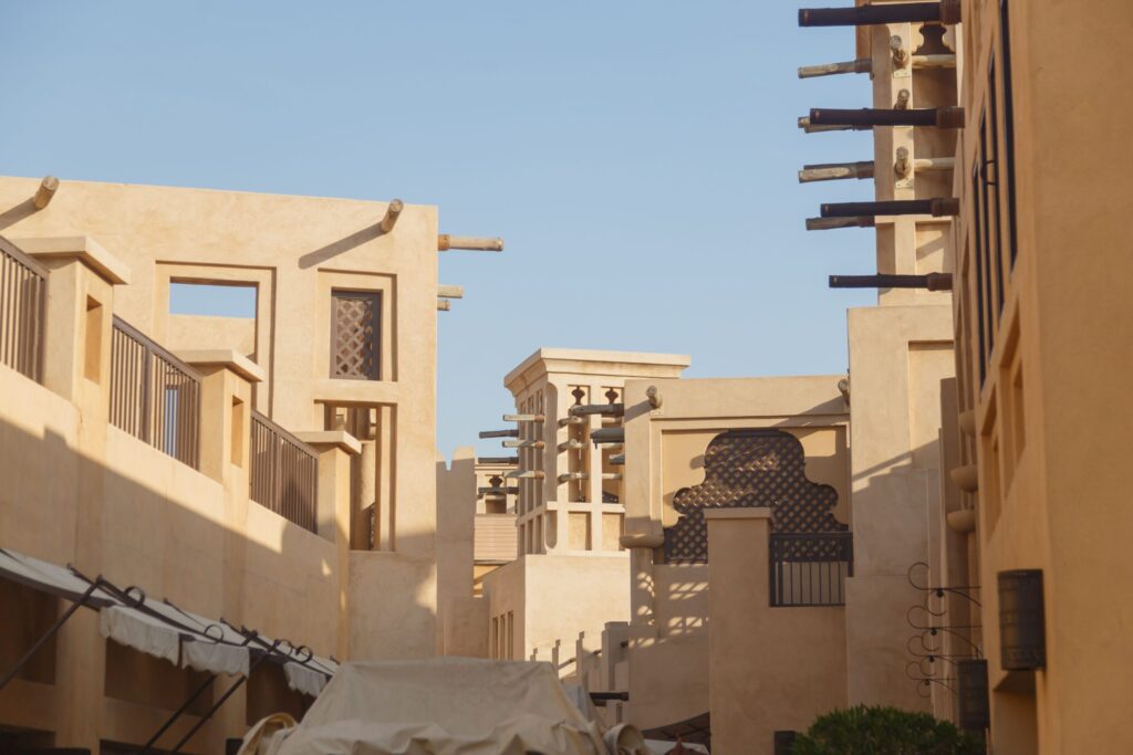Sand-coloured buildings with traditional Arabian architecture under a clear sky