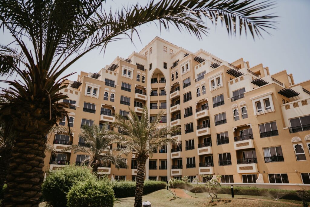 Sandstone-toned, Arabian-style low-rise apartment building with balconies and palm trees in Old Town, Downtown Dubai, near Yansoon 7