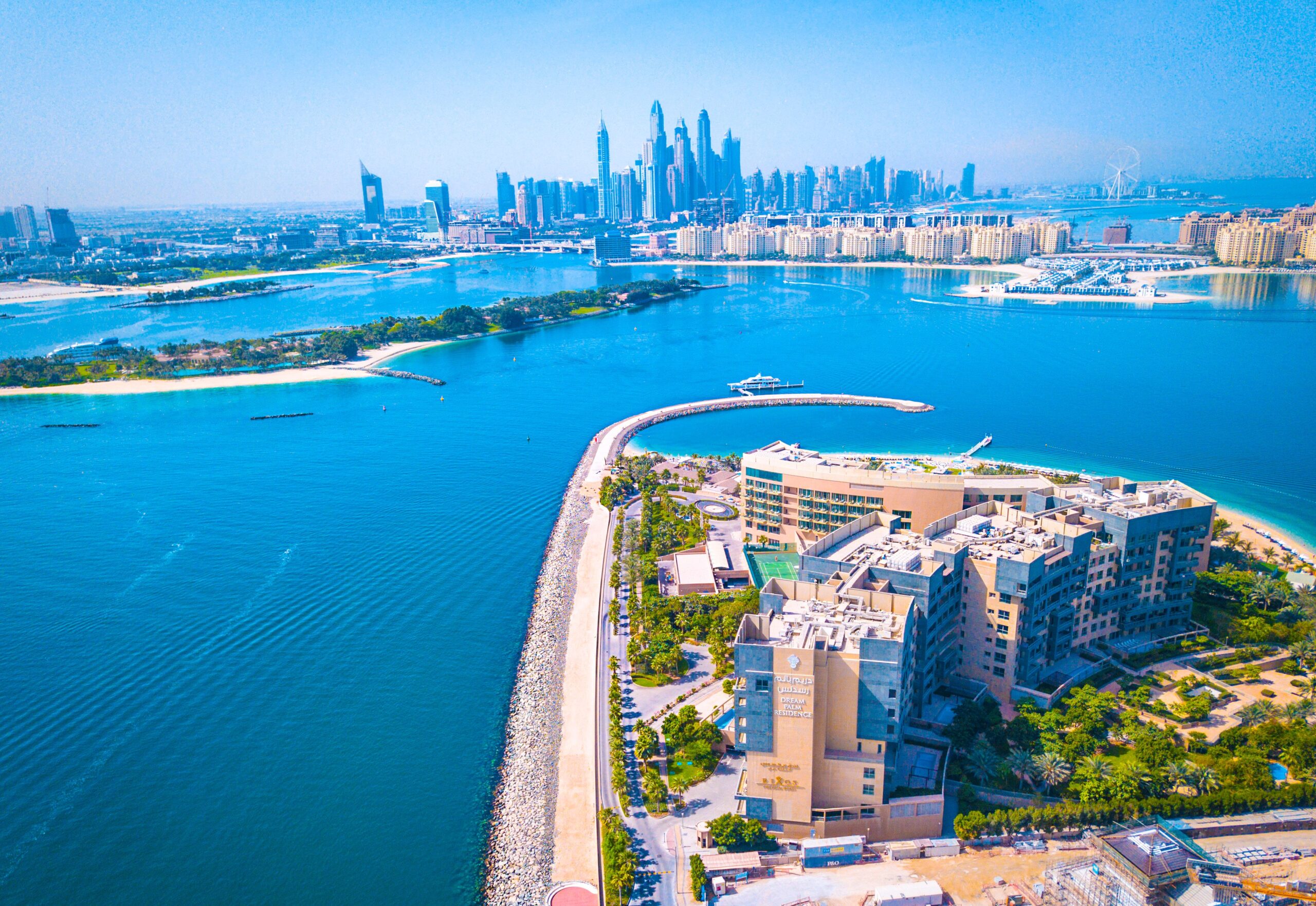 Aerial view of Palm Jumeirah's trunk with the Dubai Marina skyline in the background near One at Palm Jumeirah