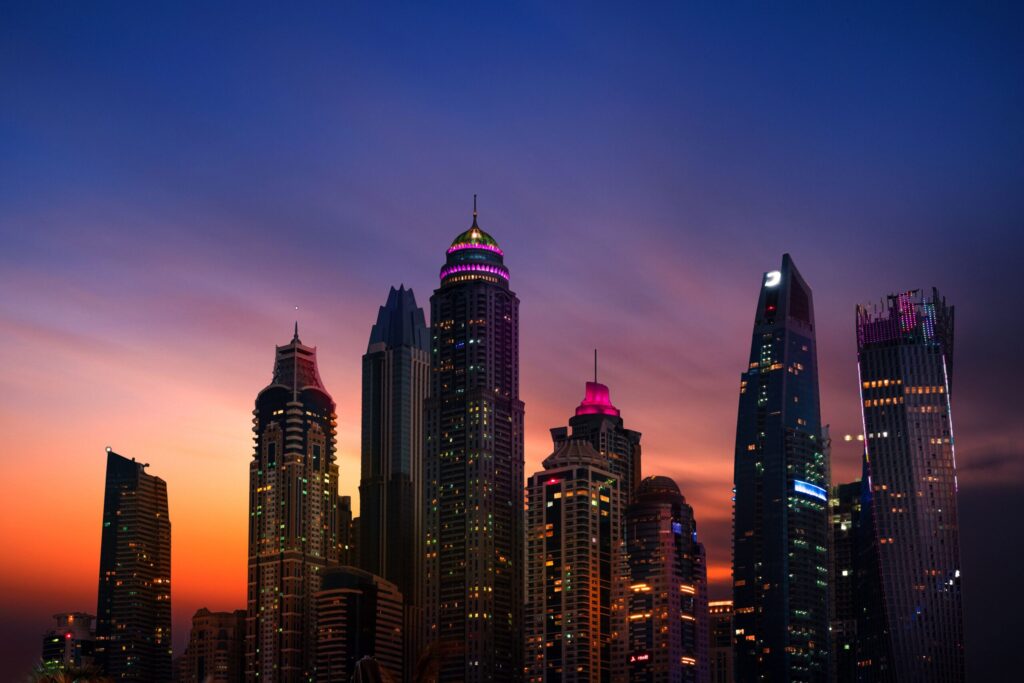 Dubai skyscrapers silhouetted against a purple and orange dusk sky