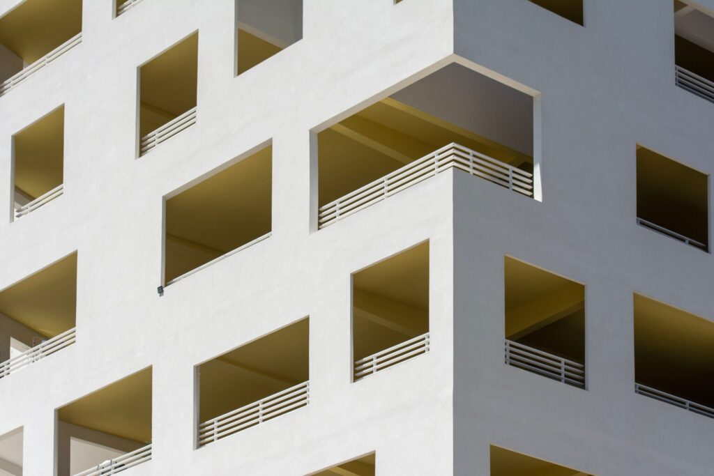 Close-up facade of a cream modern Dubai residential building with balconies near Nicholas Residence, JVC