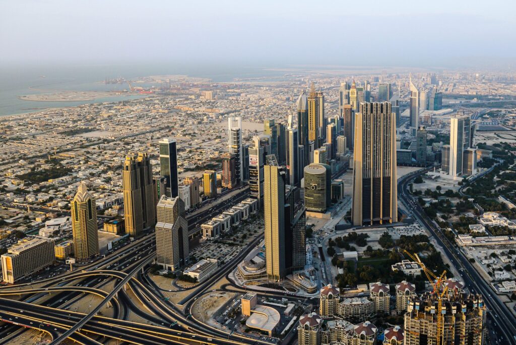 Aerial view of towers and highway interchanges in Dubai in hazy golden light