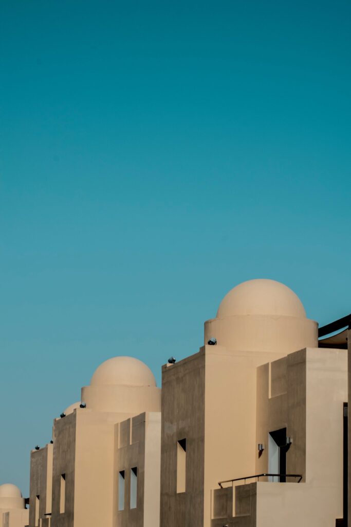Dome-topped, sandstone-toned Old Town-style buildings under a clear blue sky in Downtown Dubai, near Yansoon 5