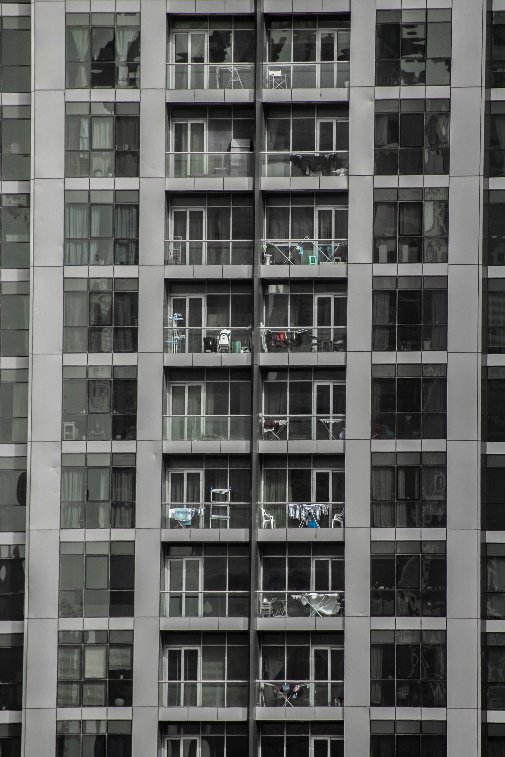 Vertical view of a contemporary apartment building facade with balconies, representative of Binghatti Gardens in Dubai Silicon Oasis, Dubai