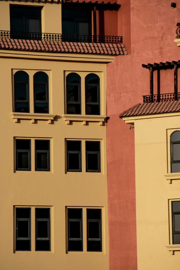 Warm terracotta and yellow low-rise Mediterranean-style apartment facade in Dubai