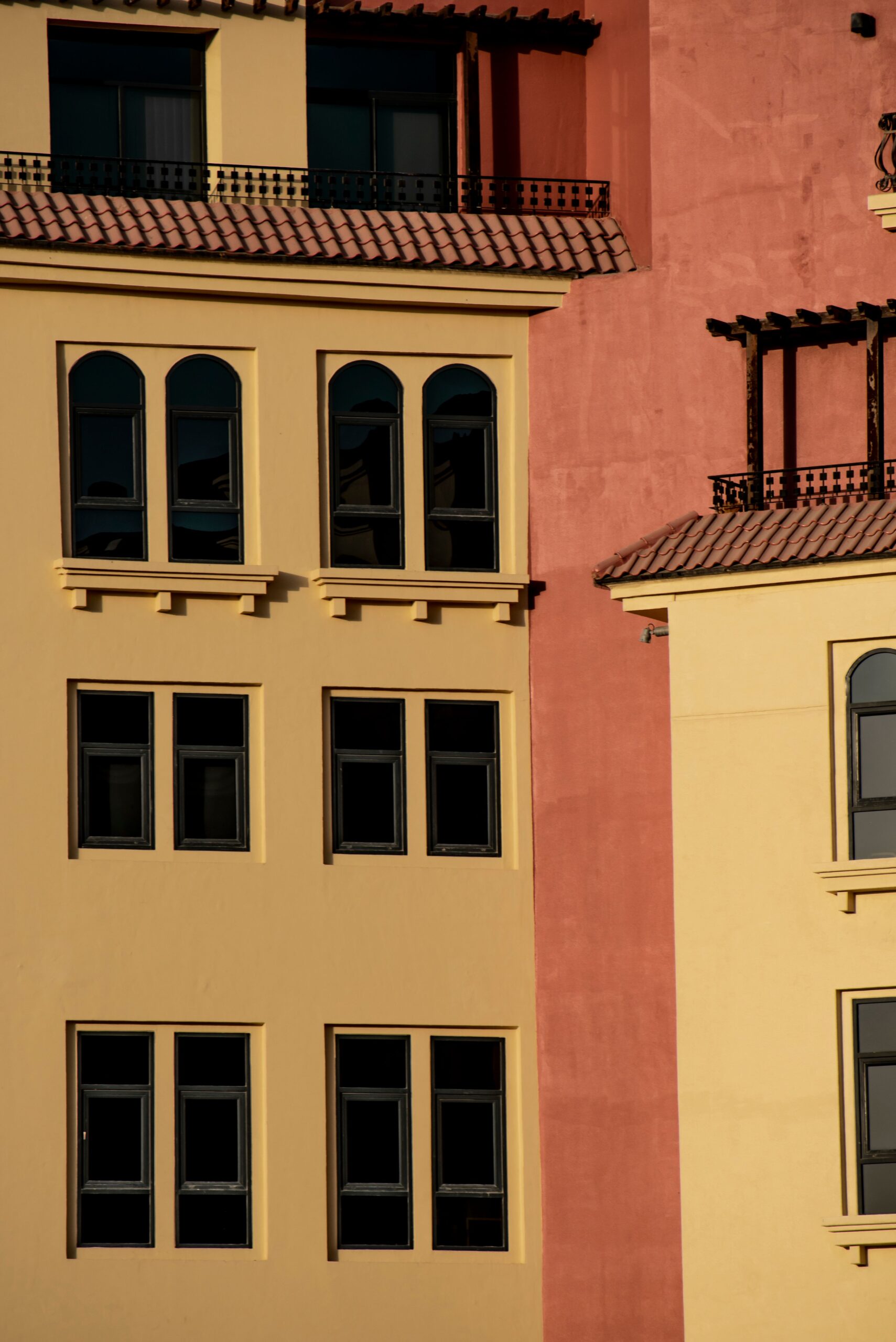 Warm terracotta and yellow low-rise Mediterranean-style apartment facade in Dubai