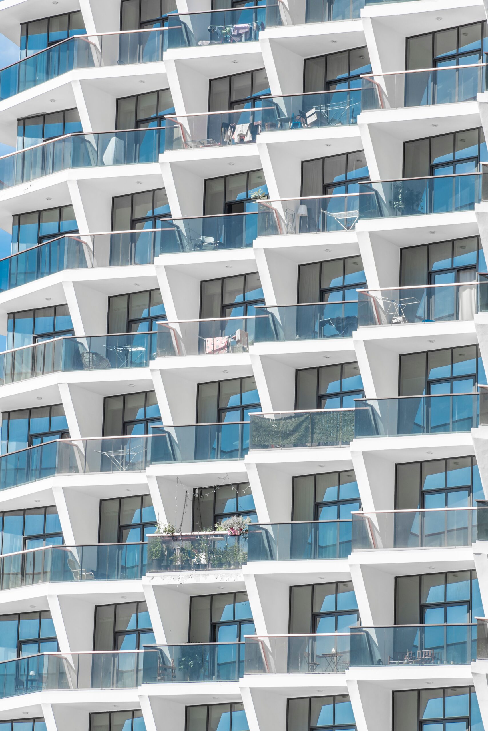 Modern geometric apartment facade with glass balconies on a Dubai residential building, near Lyra by Aurora