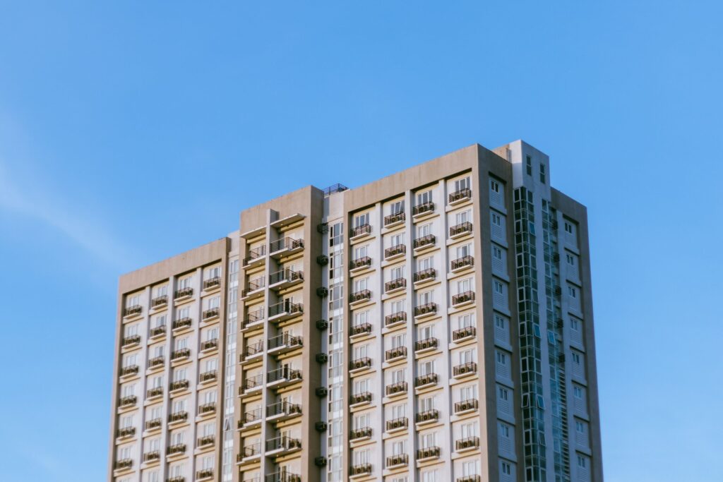 Contemporary high-rise apartment building with balconies under a clear blue sky in Dubai