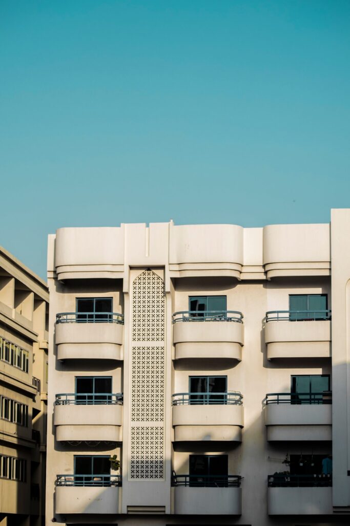 Low-rise modern Dubai residential building facade with curved balconies near Azizi Gardens, Meydan