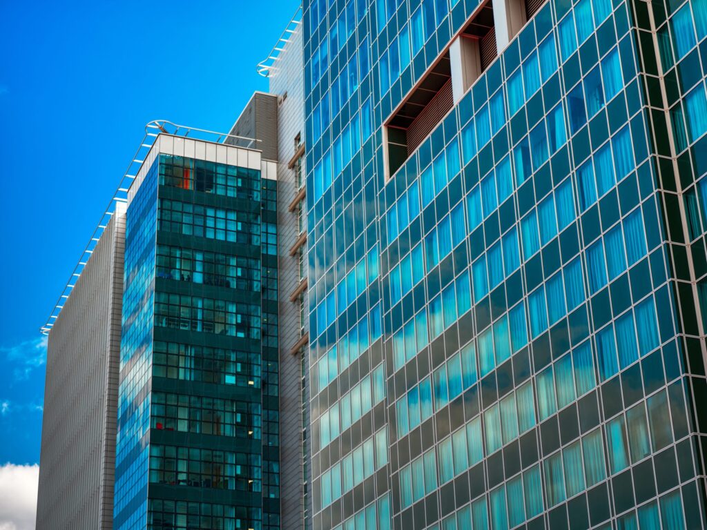 Close-up view of modern glass-facade high-rise towers under a blue sky in Business Bay, Dubai