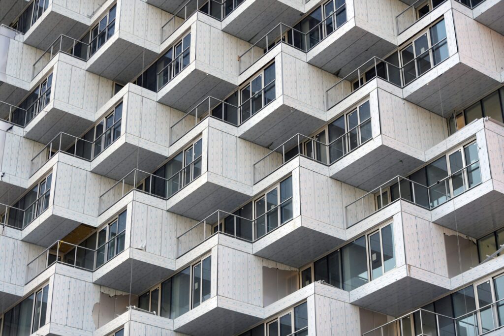Modern apartment building facade with staggered balconies and glass railings