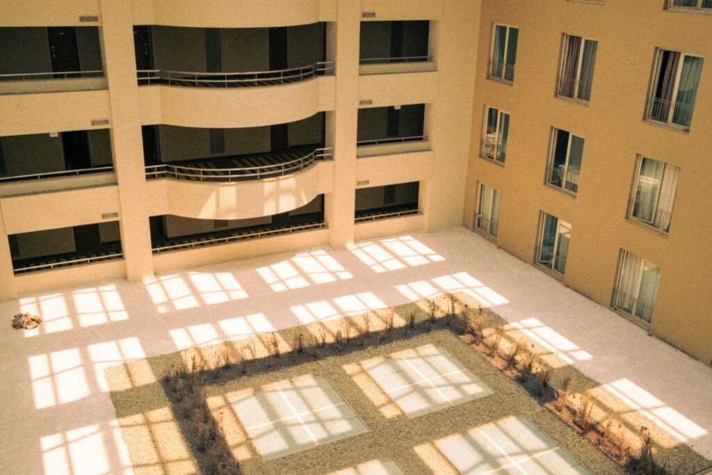 Sunlit courtyard with curved balconies at a mid-rise apartment building near The Icon Casa, JVC