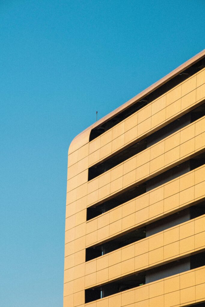 Golden-toned modern apartment building corner against a clear blue sky, Dubai