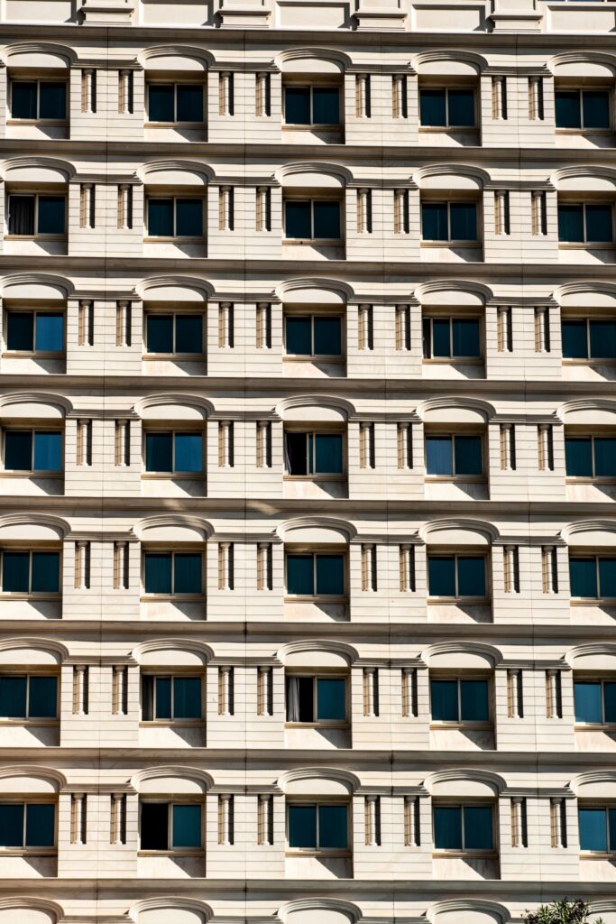 Repeating cream facade with arched window surrounds on a Dubai residential building