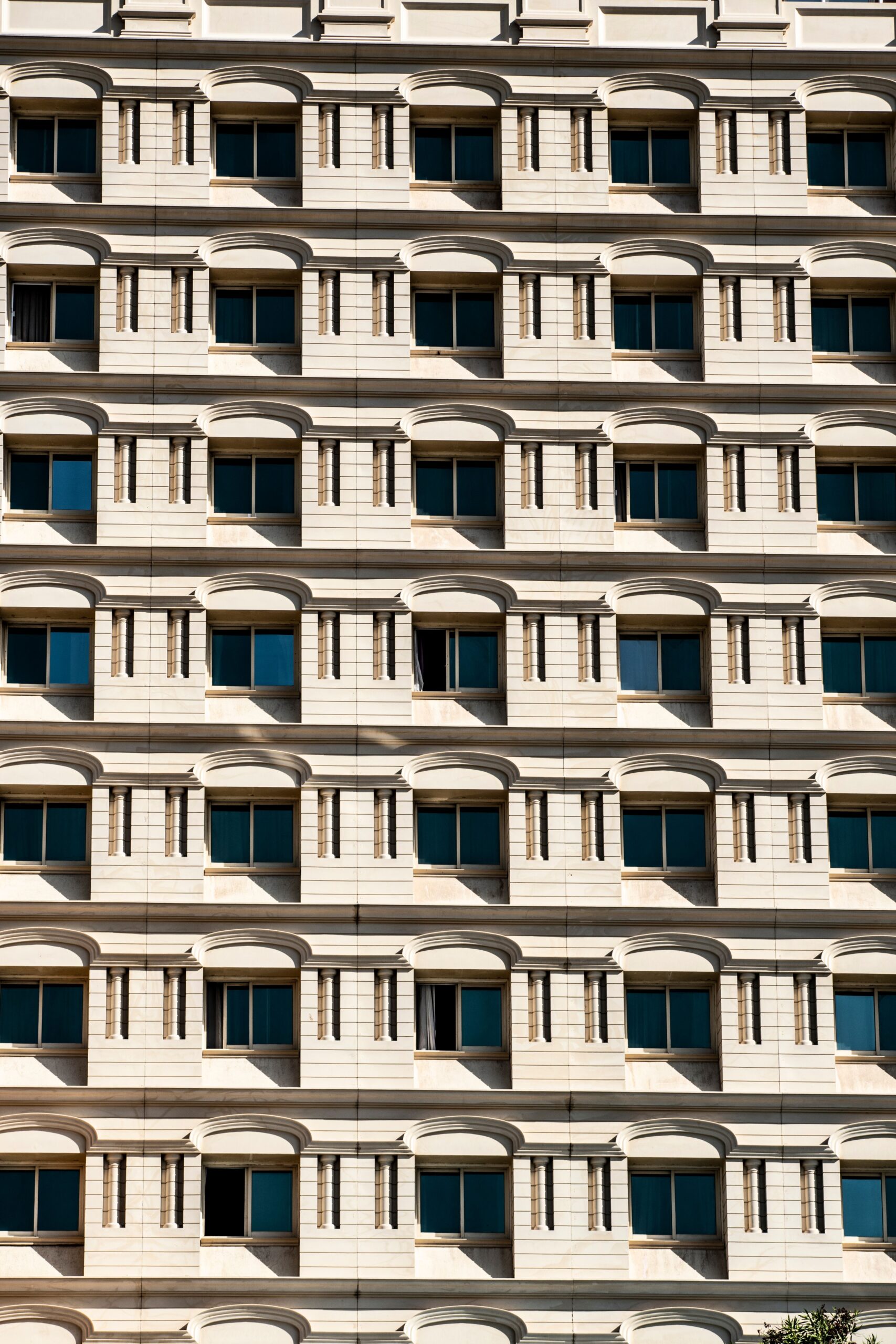 Repeating cream facade with arched window surrounds on a Dubai residential building