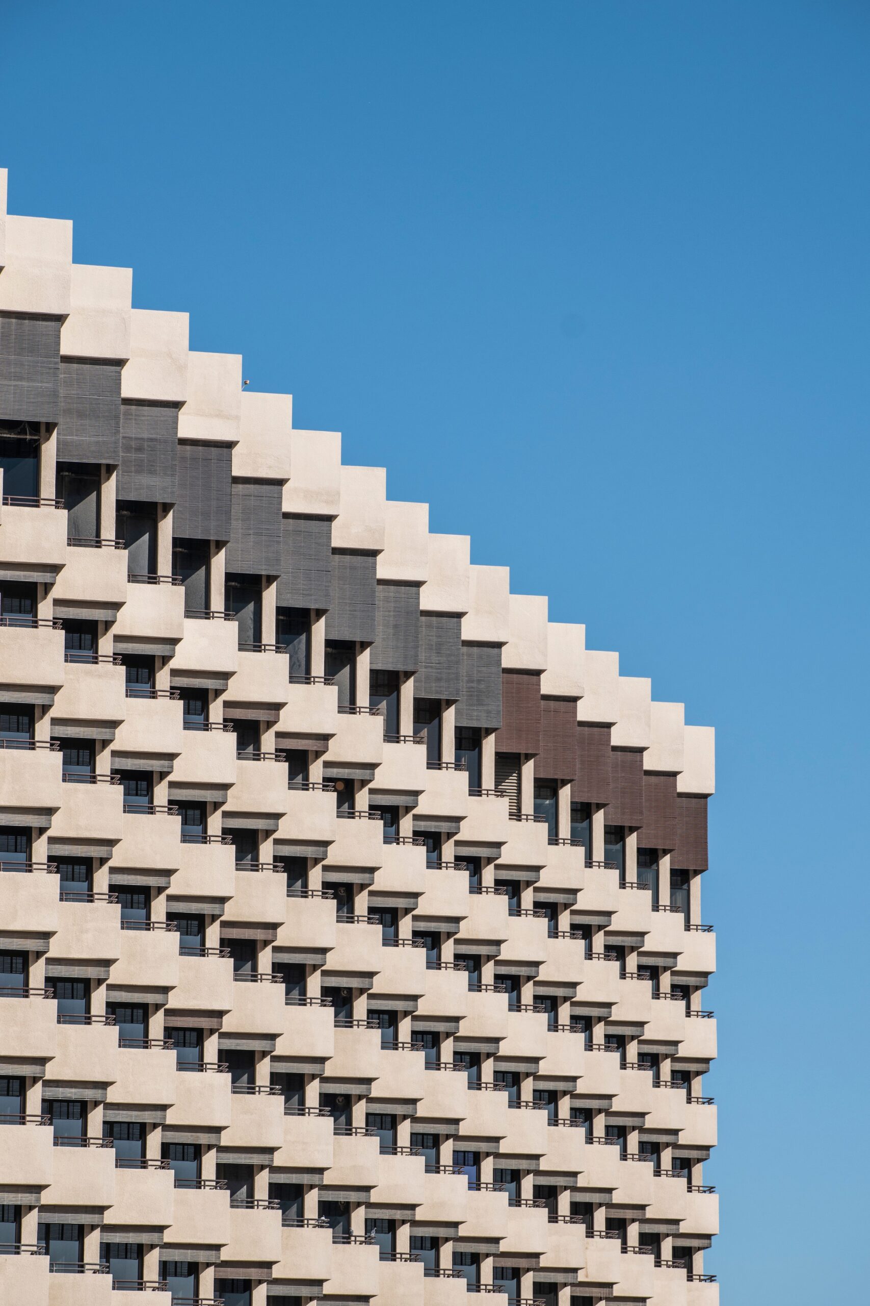 Sunlit modern apartment building facade against a clear blue sky, representative of The Hive's contemporary residential architecture in Dubai Studio City