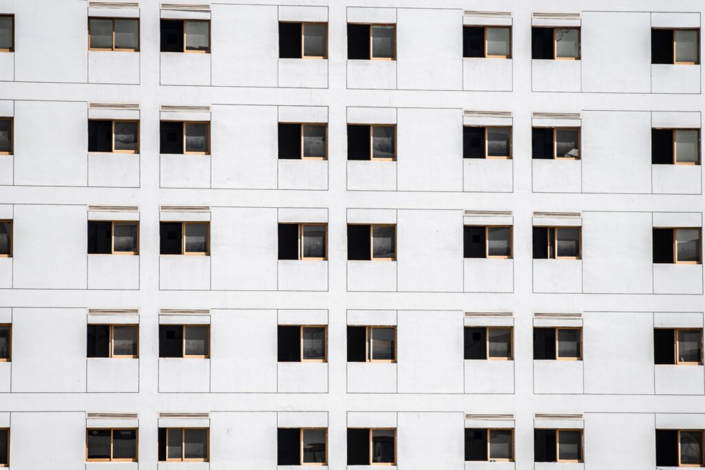 Close-up of a modern low-rise apartment building facade with uniform windows in Dubai, similar in scale to Alcove's District 11 setting