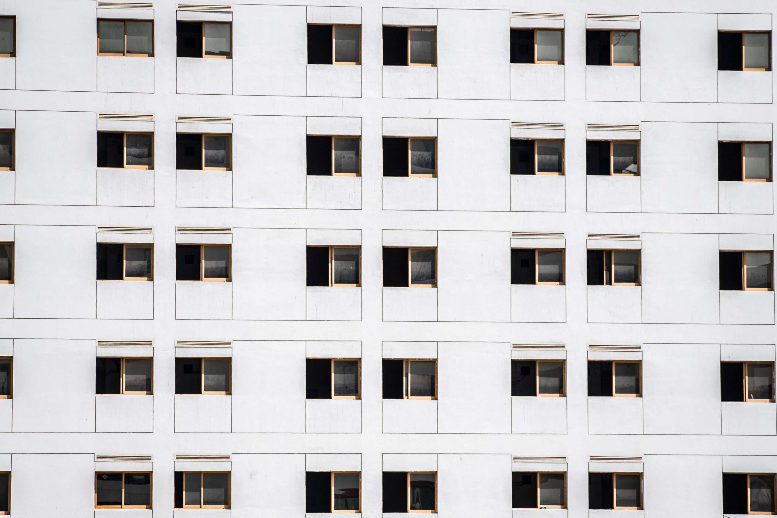 Close-up of a modern low-rise apartment building facade with uniform windows in Dubai, similar in scale to Alcove's District 11 setting
