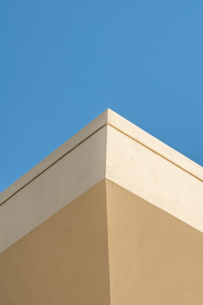 Minimalist cream and beige building corner detail against a clear blue sky in Dubai