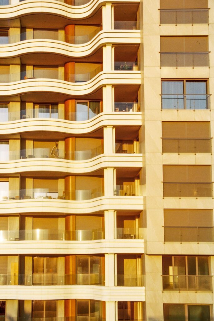 Golden hour view of a modern residential building facade with curved balconies in Dubai
