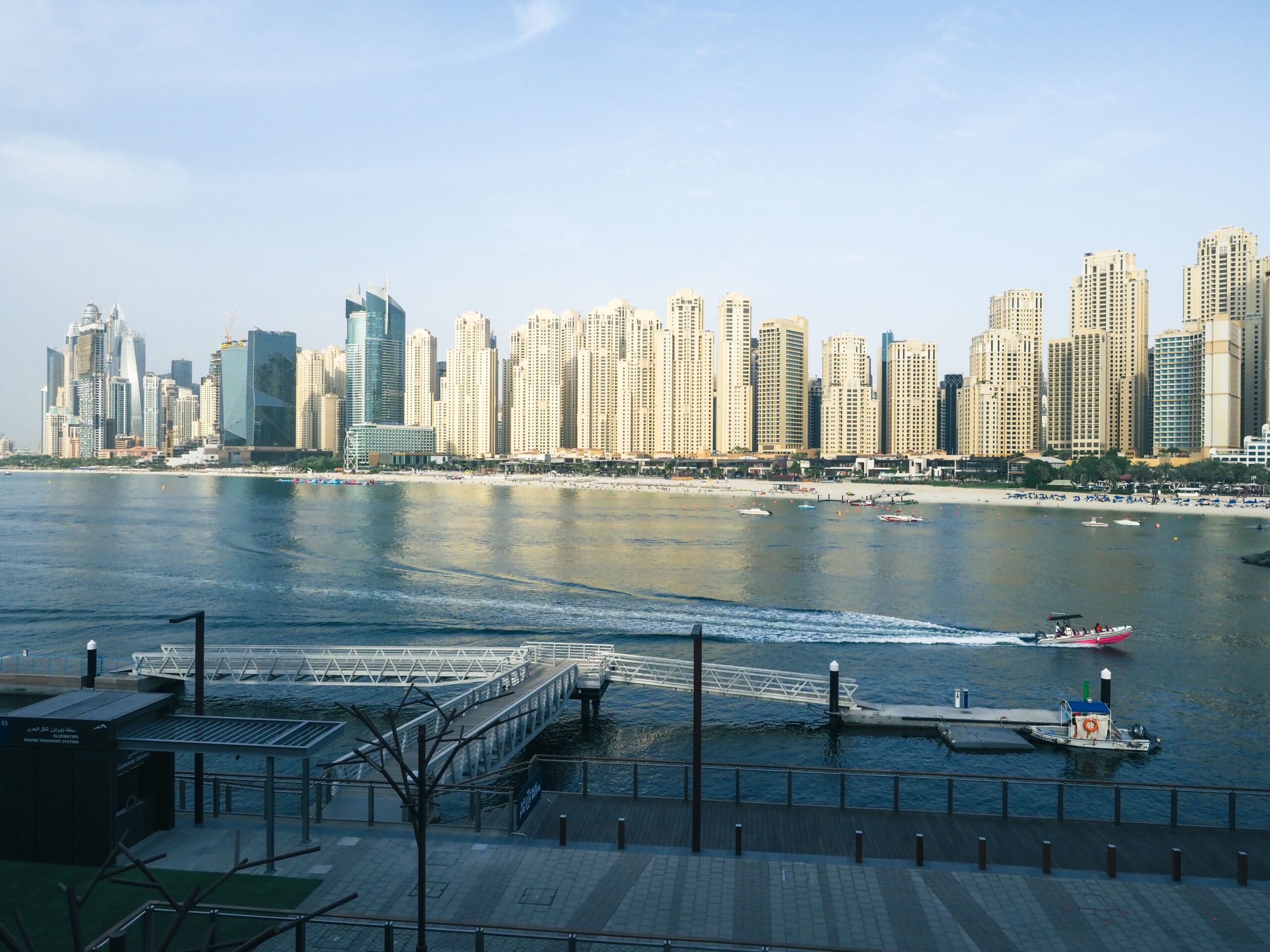 Dubai waterfront skyline with modern high-rise apartment towers reflecting over calm water