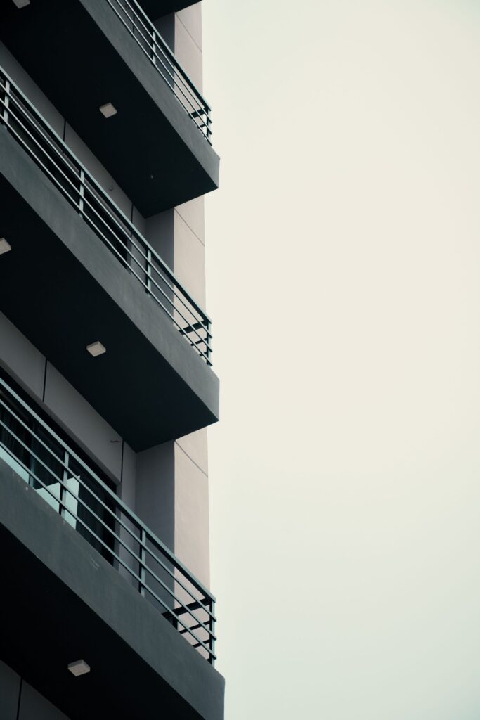Low angle close up of empty balconies on a modern residential building against a clear sky, representative of Catch Residences in JVC, Dubai