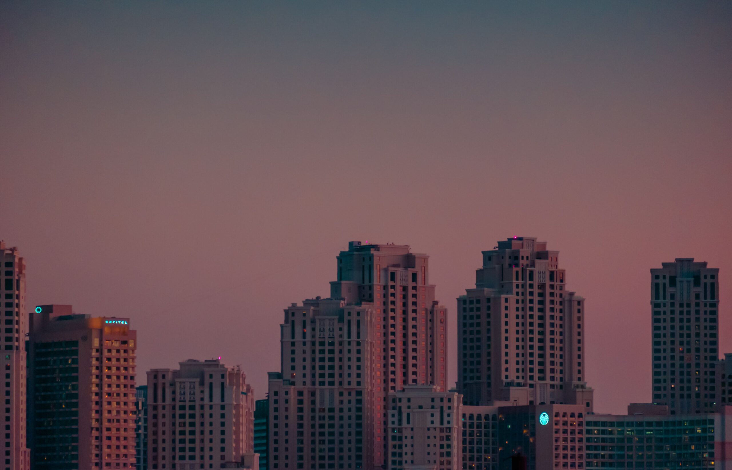 City skyline with modern high-rise apartment towers at twilight near Dubai Creek Harbour