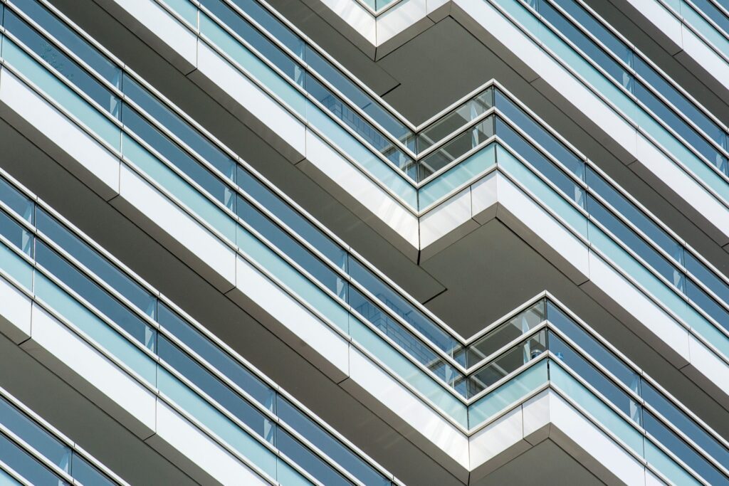 Close-up of angular chevron-patterned glass balconies on a modern high-rise facade, representative of contemporary Dubai apartment architecture