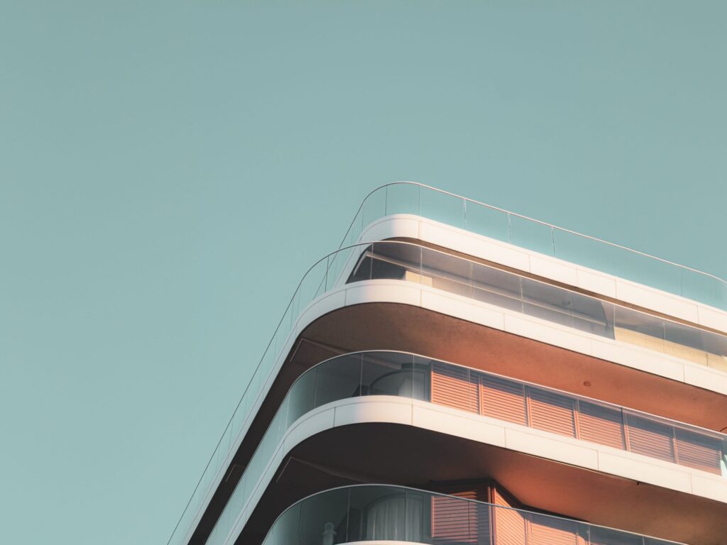 Curved white balcony corner of a modern apartment building against a clear sky