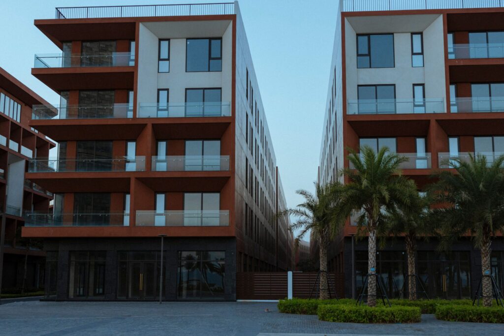 Modern low-rise Dubai residential complex with terracotta cladding and palm trees