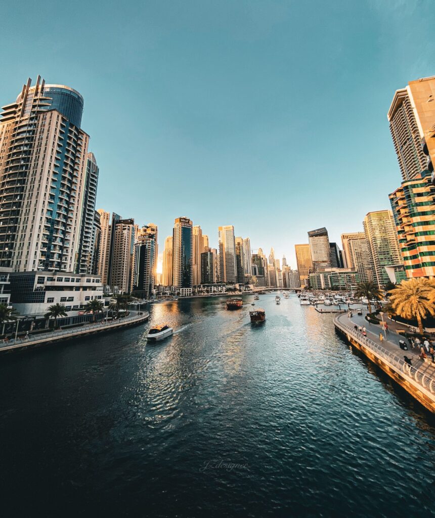 Golden hour view of Dubai Marina waterway lined with residential towers and docked boats