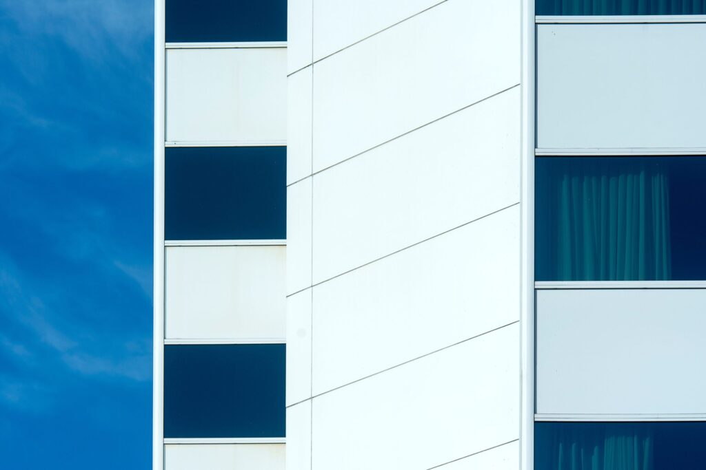 Abstract close-up of a clean white modern residential building facade, similar in style to Seslia Tower, JVT