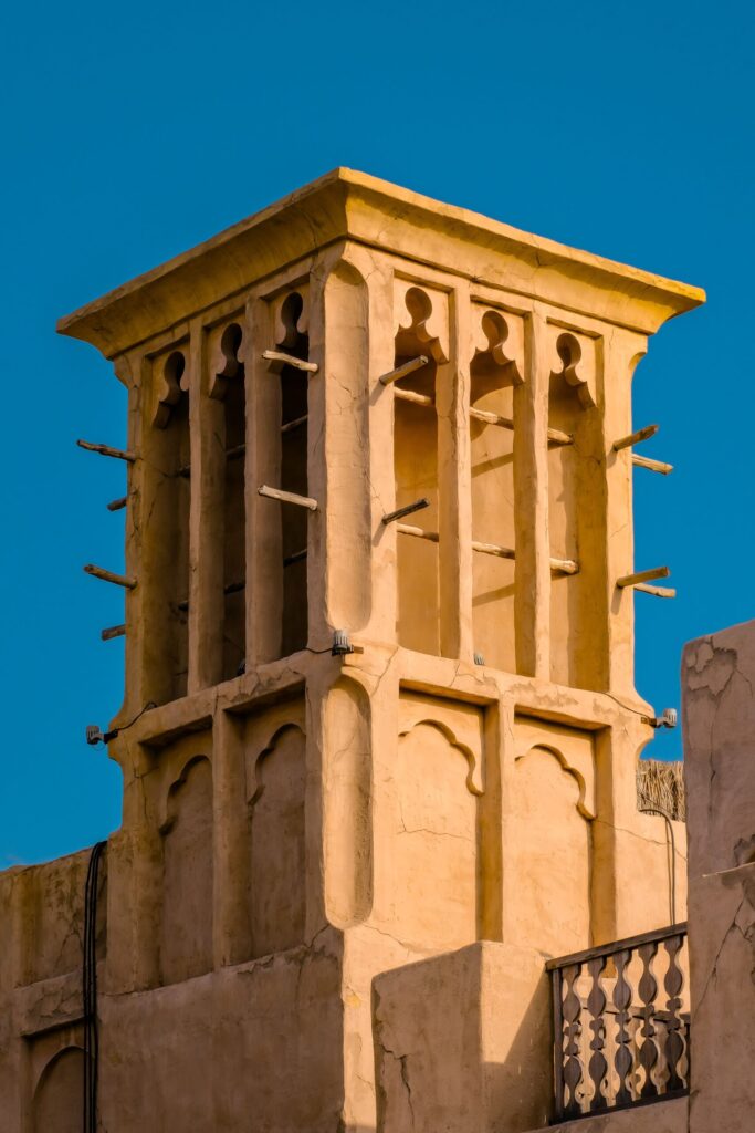 Traditional sandstone wind-tower architecture against a blue sky in Old Town, Downtown Dubai, near Reehan 6
