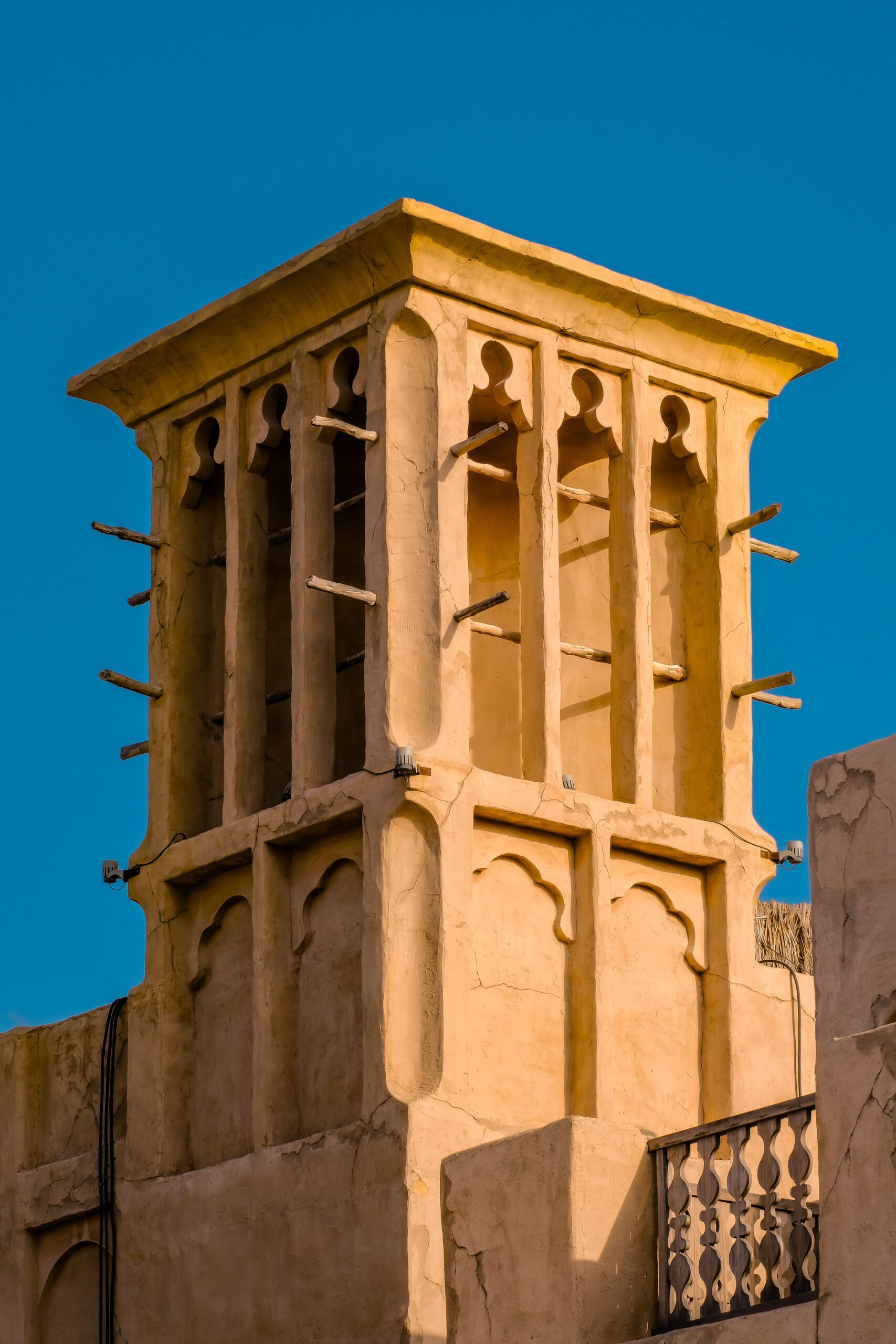 Traditional sandstone wind-tower architecture against a blue sky in Old Town, Downtown Dubai, near Reehan 6