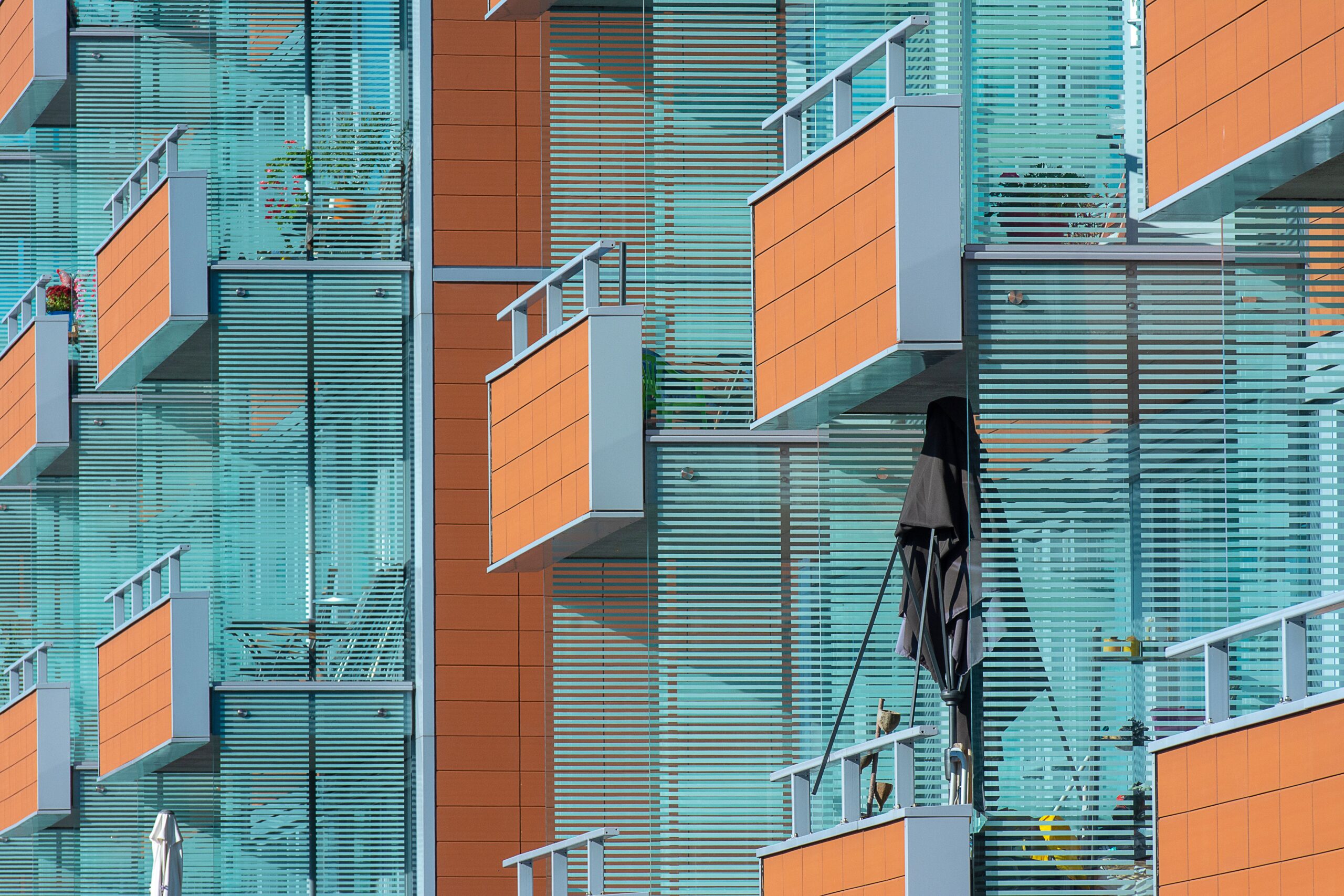 Close-up of a modern apartment building facade with colorful glass balconies in Dubai