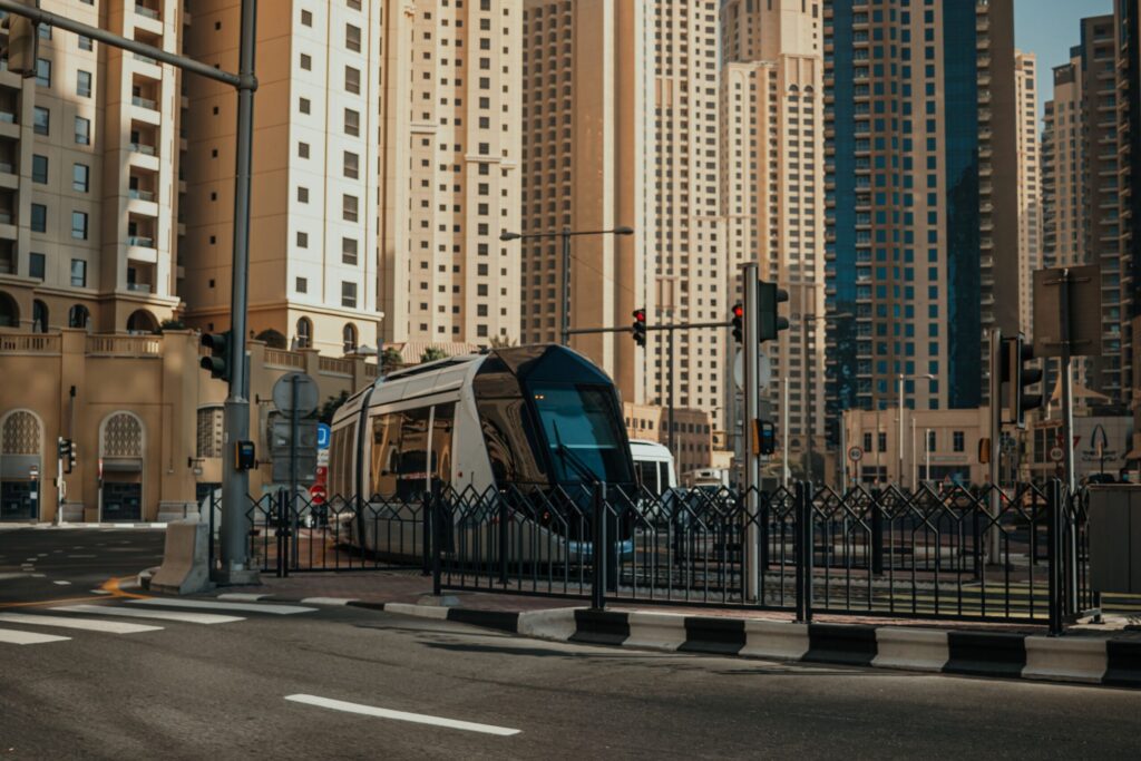 Dubai tram crossing an intersection with residential towers behind near Murjan 6, JBR