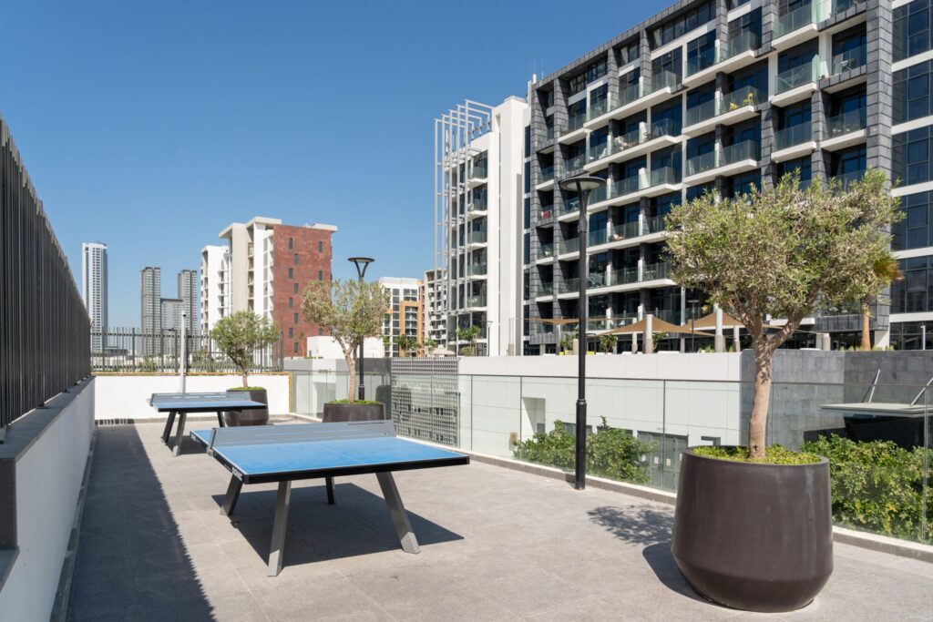 Rooftop terrace with modern mid-rise apartment buildings and Dubai skyline in the background, representative of the Dubai South area near Manam Prime