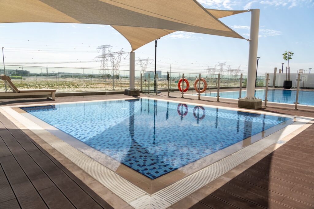Rooftop pool deck overlooking an undeveloped desert plot near Keturah Reserve, MBR City
