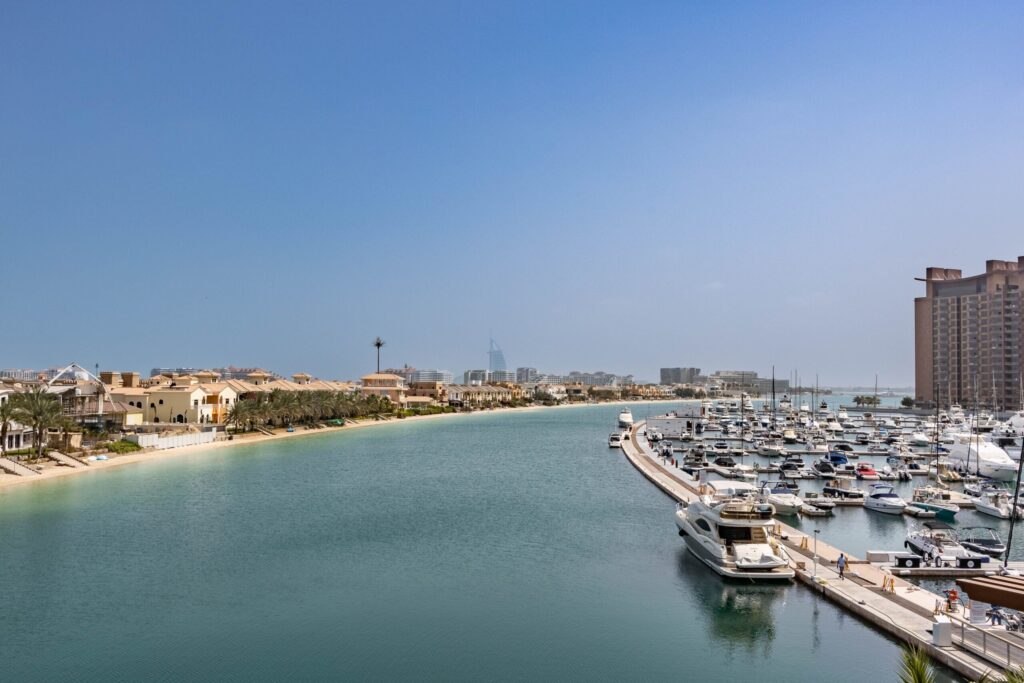 Calm lagoon waterway with yachts and a waterfront residential tower near District One, MBR City, Dubai