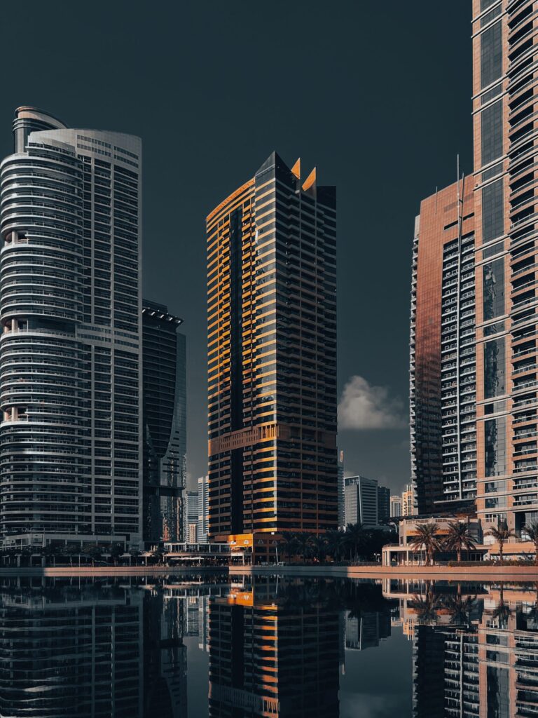 Jumeirah Lake Towers skyscrapers at dusk with orange-lit facades reflecting in the lake, representative of Lake Side Residence in JLT Cluster A