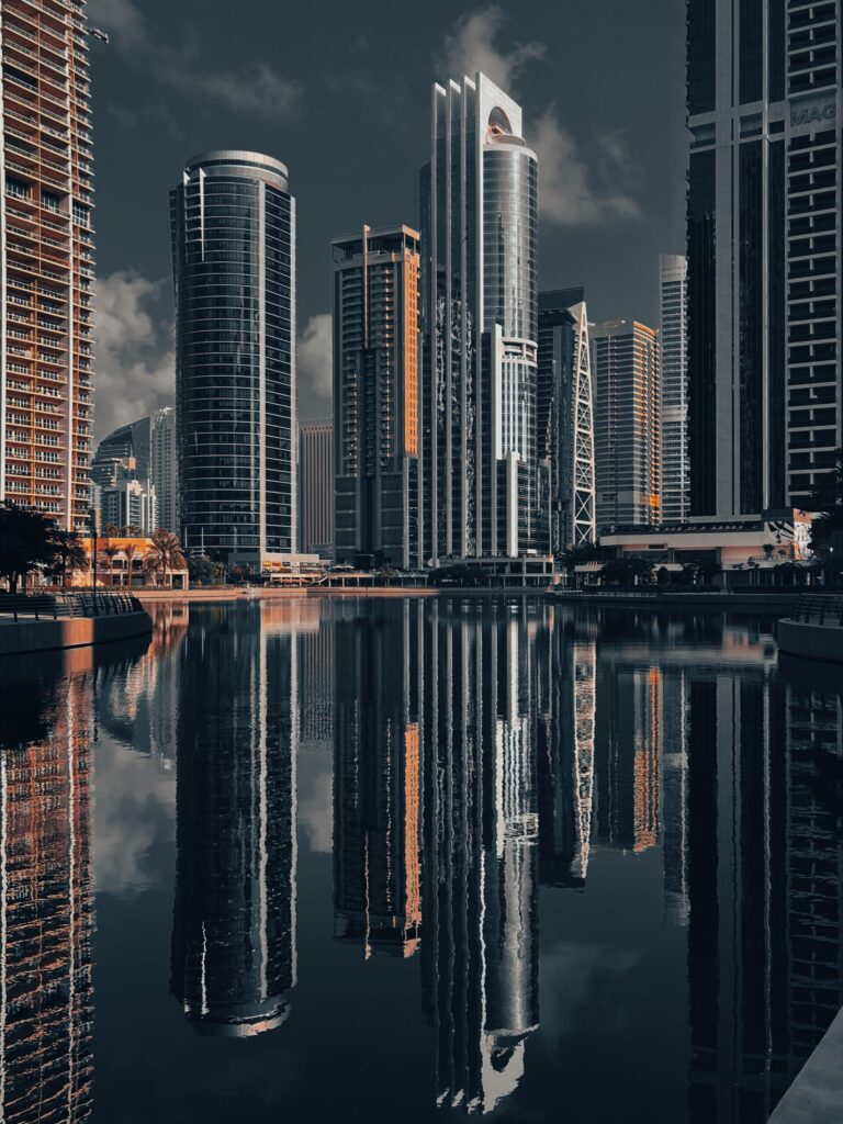 Dubai skyline with high-rise towers reflected in a calm waterfront lake, representative of Lake View in Jumeirah Lake Towers Cluster B